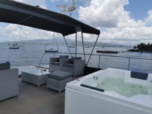 La cubierta superior de la casa flotante con su salón, un jacuzzi y una vista de la bahía de Fort-de-France y el Monte Pelée.